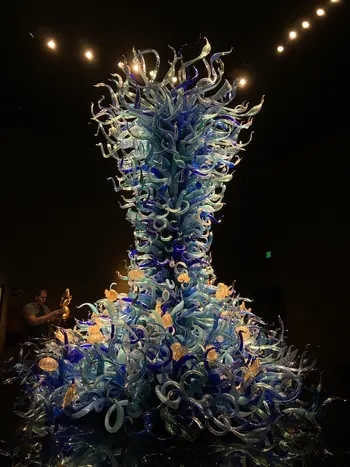 Blue Chihuly glass sculpture in a dimly lit room