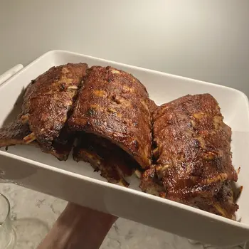 Freshly smoked spare ribs stacked in casserole dish